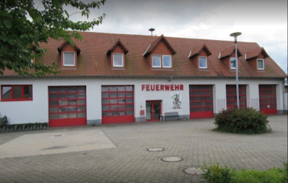 Das Gerätehaus der Feuerwehr Machern am Schlossplatz mit roten Toren