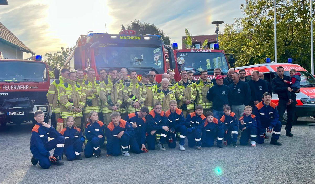 Gruppenfoto der Feuerwehr Machern mit Einsatzabteilung und Jugendfeuerwehr vor dem neuen HLF 20 und den anderen Fahrzeugen