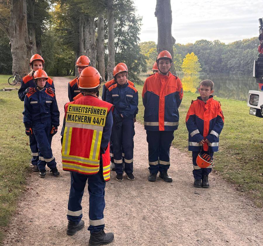 Jugendliche in Feuerwehrkleidung stehen beim Antreten vor dem Einheitsführer