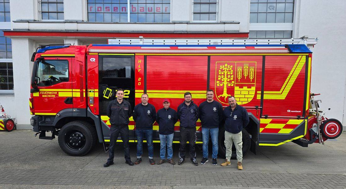 Sechs Kameraden der Feuerwehr Machern stehen vor dem neuen HLF 20 am Werk von Rosenbauer in Luckenwalde
